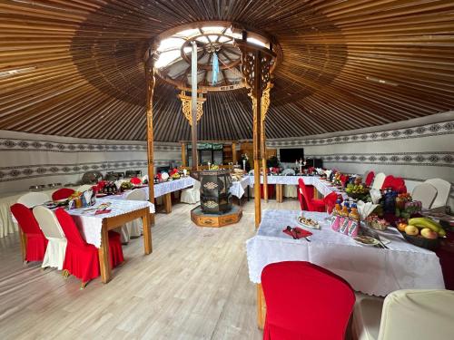 a large dining room with tables and red chairs at Sara's Camp in Dzuunmod