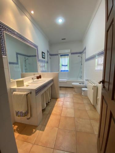 y baño con lavabo, aseo y espejo. en Casa Villa Jarocha, en Recas