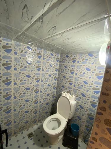 a bathroom with a toilet with blue and white tiles at Ayour Beach House 1 in Imsouane