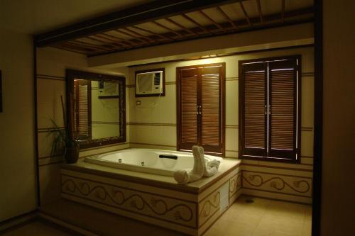a large bathroom with a tub and a mirror at Auto Hotel Mediterraneo in Veracruz