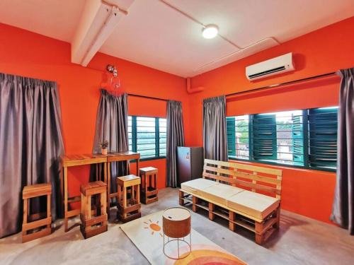 uma sala de estar com paredes cor-de-laranja e mobiliário em madeira em Ipoh town centre - safari 5 pax(2BR) em Ipoh