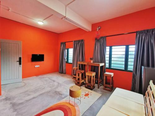 uma sala de estar com paredes cor de laranja e uma secretária em Ipoh town centre - safari 5 pax(2BR) em Ipoh