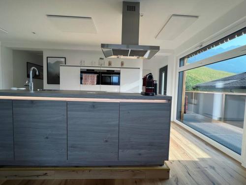 cocina con encimera grande y ventana grande en Bergpanorama Lodge — Alpenidylle en Thaur