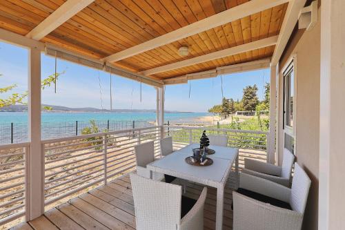 un porche con mesa, sillas y el océano en Camp Ana, en Biograd na Moru
