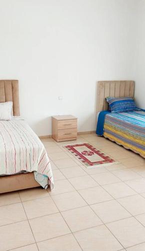 1 dormitorio con 2 camas y suelo de baldosa en Condo Agadir, Morocco, en Agadir