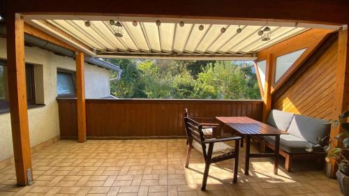 eine Terrasse mit einem Tisch, Stühlen und einem Fenster in der Unterkunft Wohnung am Spitalberg in Klagenfurt am Wörthersee
