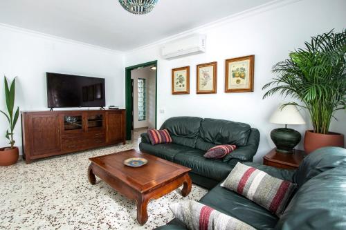 sala de estar con sofá y TV en Newly furnished cozy house next to the beach en Calafell