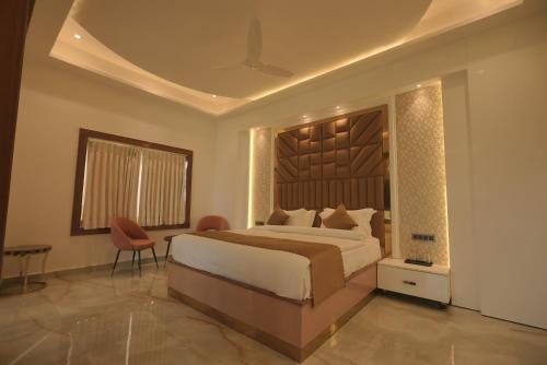 アリーガルにあるGolden Stone Resortsのベッドルーム1室(大型ベッド1台、テーブル、椅子付)