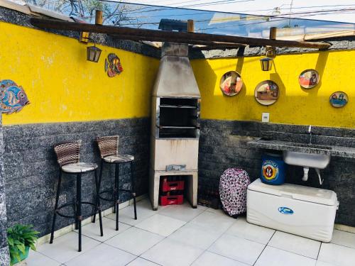 een keuken met krukken en een gele muur bij Casa riviera in Paraty