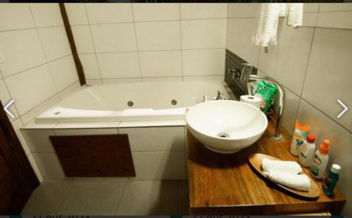 a bathroom with a sink and a bath tub at Pousada Bambu Dourado in Marau