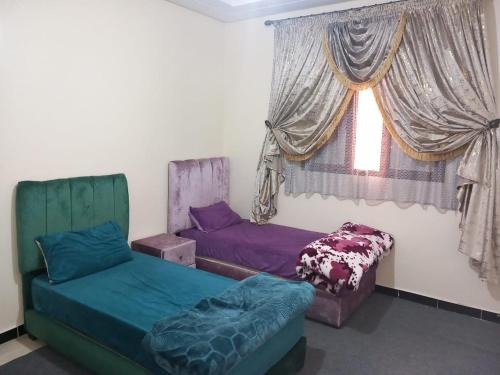 Habitación con 2 camas y ventana en إقامة الخيمة للشقق المفروشة, en Laayoune