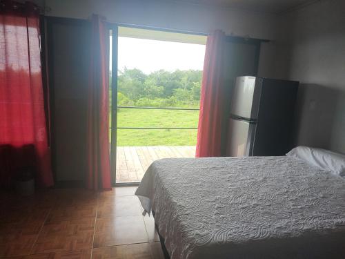 1 dormitorio con cama y ventana grande en Villas El Alto 1, en Tambor