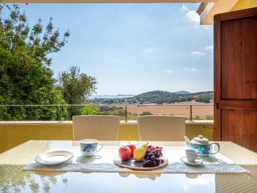 a table with a plate of fruit on top of it at Ollastu Apartments Villasimius in Villasimius