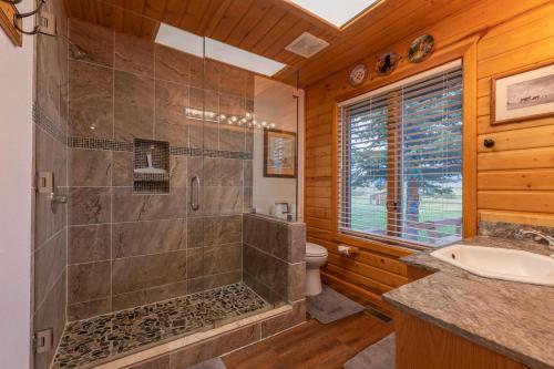 a bathroom with a shower and a toilet and a sink at Teton Riverfront Property in Victor