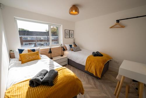 1 dormitorio con 2 camas y ventana en Exquisite 6 Bedroom Luxury Home Manchester, en Mánchester