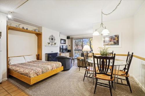 a bedroom with a bed and a table and chairs at Ski home to this cozy one bedroom condo Whiffletree F5 in Killington