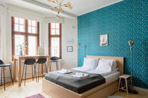 um quarto com uma cama e uma parede azul em Renovated Design District Studio em Helsinque