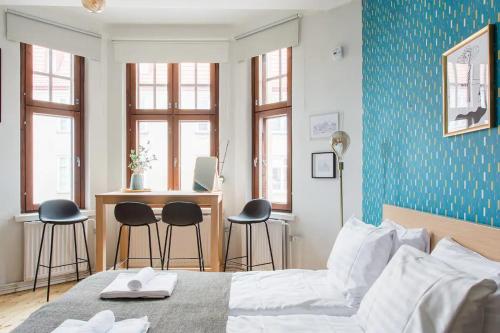 um quarto com uma cama, uma secretária e cadeiras em Renovated Design District Studio em Helsinque