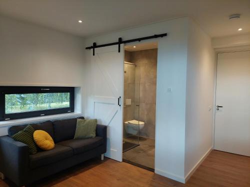 a living room with a couch and a walk in shower at Smaakvol Slochteren in Slochteren