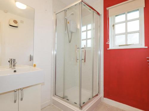 a glass shower in a bathroom with a sink at Bracken Cottage in Bodmin