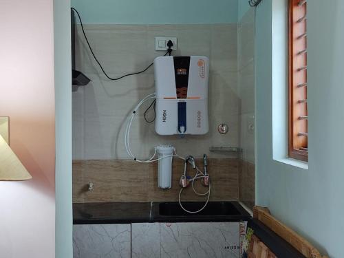 baño con lavamanos y secador de pelo en la pared en Vrindavan, en Mysore