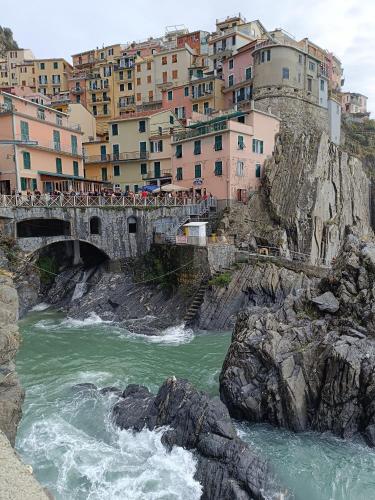a bridge over a river in front of buildings at CasafioRita in Mattarana