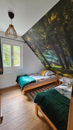 um quarto com duas camas e uma grande pintura na parede em Kotula em AdamÃ³w