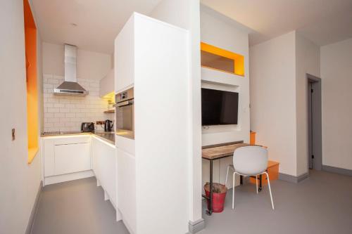higgihaus Apartment 3 Clare Street Aparthotel Central Location في بريستول: مطبخ أبيض مع طاولة وكرسي