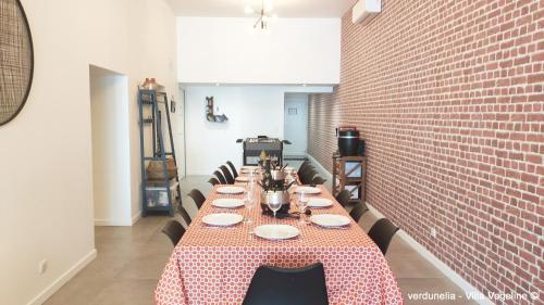 a long table in a room with a brick wall at Séjour en famille ou entre amis: Sauna, Billard in Bains-les-Bains
