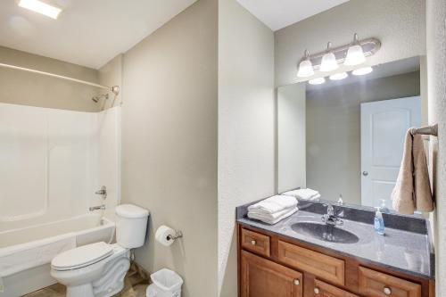 a bathroom with a sink and a toilet and a mirror at Lovely Lawrence Home - 3 Blocks to KU! in Lawrence
