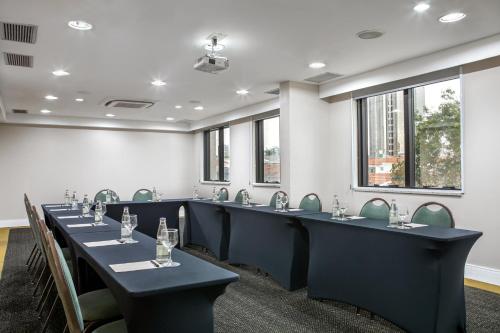 a conference room with tables and chairs and windows at São Paulo Tatuape, Affiliated by Meliá in Sao Paulo