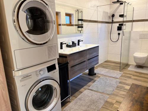 a bathroom with a washing machine and a washer and dryer at Reiterbauer Chalet 