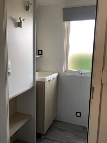 uma pequena casa de banho com um lavatório e uma janela em La Côte d Opale - Le Portel - Vue sur mer - P31 - climatisé-2018 em Le Portel