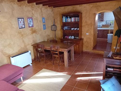 sala de estar con mesa de madera y sillas en Casa de los Arcos, en Mocanal