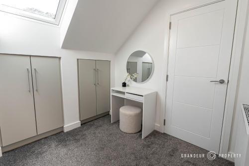 a white bathroom with a vanity and a mirror at Townhouse near BEACH, Sleeps 8, Garden & Parking - Carbery Lux in Bournemouth