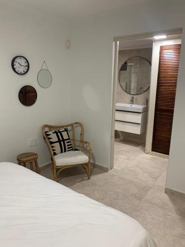 a bedroom with a bed and a mirror and a chair at Piscadera Bay Resort #16 in Sint Michiel