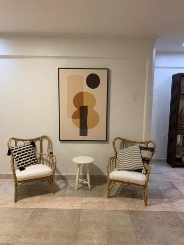 two chairs and a table in a room with a picture at Piscadera Bay Resort #16 in Sint Michiel