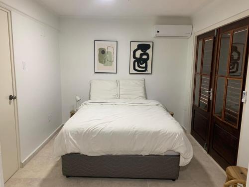 um quarto com uma cama grande e lençóis brancos em Piscadera Bay Resort #16 em Dorp Sint Michiel