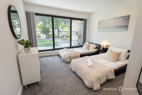a living room with two beds and a window at Townhouse near BEACH, Sleeps 8, Garden & Parking - Carbery Lux in Bournemouth