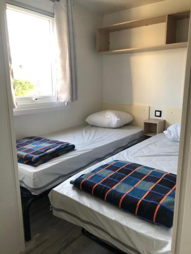two beds in a small room with a window at La Côte d Opale - Le Portel - Vue sur mer - P31 - climatisé-2018 in Le Portel