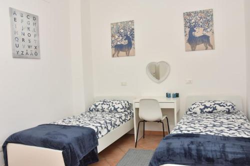 a bedroom with two beds and a desk with a chair at Home in Certosa Pigneto con parcheggio in Rome