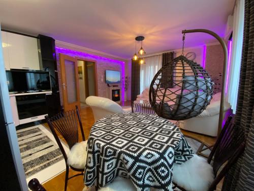 une chambre avec une table et une chambre avec un éclairage violet dans l'établissement Royal Place Apartment - East Sarajevo, à Lukavica