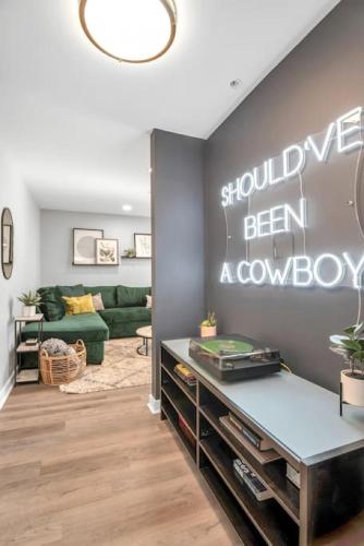a living room with a green couch and a wall at Walk to Downtown Broadway with Pool, Free Parking, and Gym in Nashville