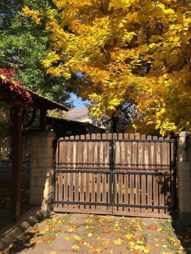 a wooden fence in front of a tree with yellow leaves at Home-restaurant in Vanadzor in Vanadzor