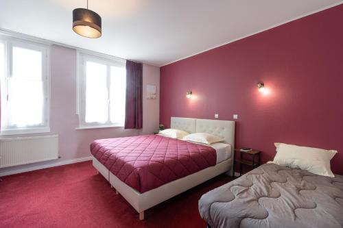 two beds in a room with purple walls at Hôtel Le Caddy in Le Touquet-Paris-Plage