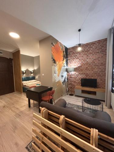 a living room with a couch and a brick wall at BoleslaviaApartments - Apartament Simon 2, Center, air conditioning in Bolesławiec