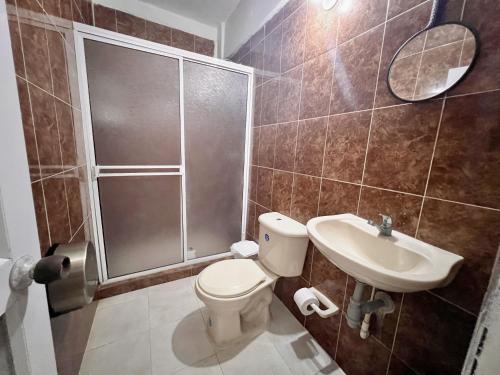 a bathroom with a shower and a toilet and a sink at Hostal Mom Mariela in San Andrés