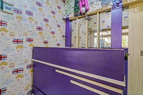 une porte violette dans une pièce dotée d'un mur recouvert de drapeaux cassis dans l'établissement OYO Life 93120 Apartement Gateway Cicadas By Sarana Cipta Mahakarya, à Bandung