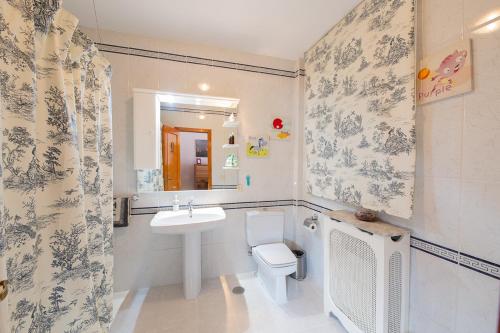 a bathroom with a sink and a toilet and a mirror at Pregonero House in Granada