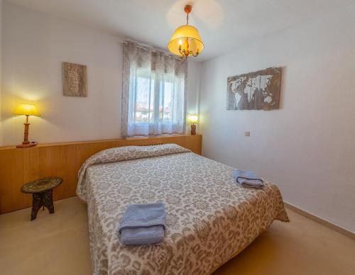 a bedroom with a bed with two towels on it at Pregonero House in Granada